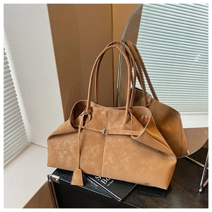 Detail of vintage caramel suede tote bag with elegant pleated design and metal buckle