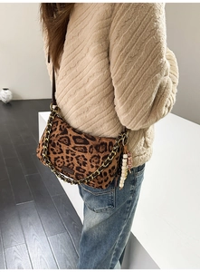 Close-up of leopard print faux fur bag with gold chain strap and pearl charm detail