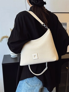 Elegante borsa a tracolla plissettata bianco crema con trama a scacchi indossata da modella