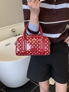 Chic red polka dot pillow bag with dual handles and stylish glossy finish for women