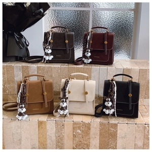 Detailed display of vintage leather crossbody bags in five colors with puppy pendants