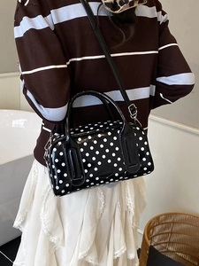 Chic black and white polka dot boston bag with glossy finish and detachable strap