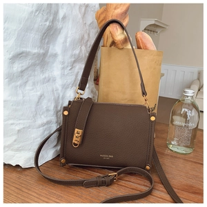 Detail view of dark brown litchi grain leather bag with vintage golden hardware