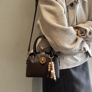 Detailansicht der dunkelbraunen Vintage-Muscheltasche mit Goldverschluss und Quaste