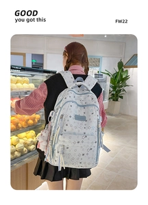 Detalle de mochila azul claro con estrellas, colgante de conejo y adornos de borlas