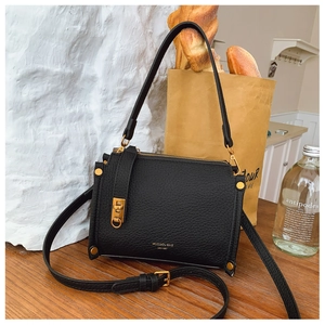 Detail of vintage black pebble leather bag with gold hardware and elegant brand stamping