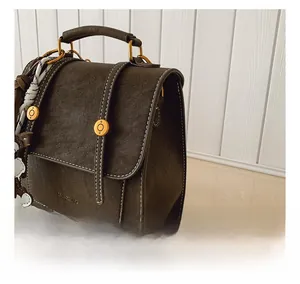 Detail showing retro dark brown frosted backpack with white contrast stitching and gold buckle