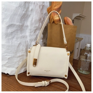 Close-up of cream square bag with lychee grain texture and gold MUCOOU BAG logo