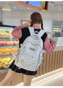 Detalle de mochila blanca con estrellas azules y colgante de peluche decorativo