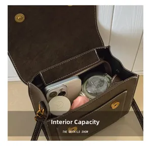 Detail showing the internal storage capacity of the brown suede handbag with white stitching