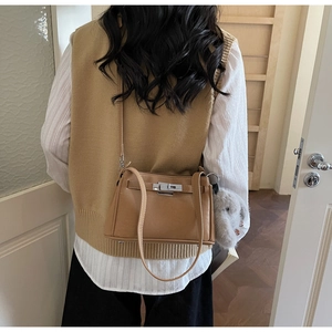 Detail of caramel faux leather Kelly bag with silver hardware and plush rabbit charm