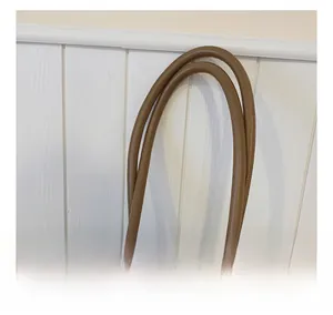 Detail of a brown leather tote bag handle featuring an elegant printed silk scarf accent