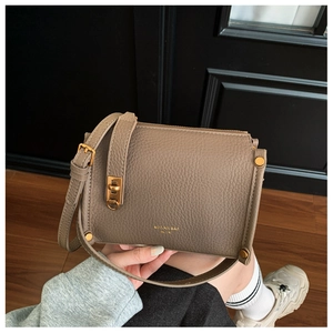 Detail of tan lychee pattern leather shoulder bag with elegant gold metal hardware