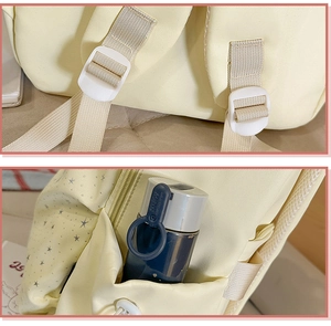 Detail of adjustable strap and side pocket for water bottle on cream star print backpack