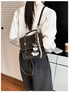 Detail of vintage grey satchel bag featuring a cute Schnauzer dog leather pendant accessory