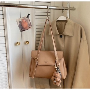 Détail du sac cabas en cuir grainé avec pendentif ours en peluche et bandoulières