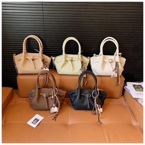 Detail view of stylish bucket bags in multiple colors with woven pendants and leather texture