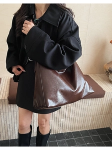 Détail du cuir ciré marron foncé d'un grand sac cabas vintage avec texture de haute qualité
