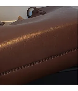 Close-up of dark brown tote bag showing soft litchi texture and premium leather grain