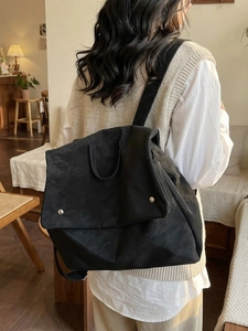 Women's minimalist black matte backpack with silver metal buckle in a casual lifestyle setting
