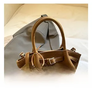 Detail of caramel lychee grain leather bucket bag with silver hardware and bead charm