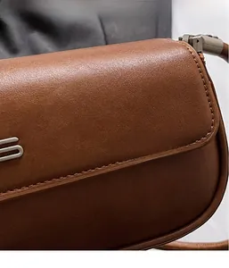 Detail of premium brown leather texture with precise stitching and silver metal hardware