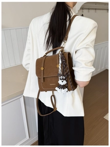 Brown vintage faux leather backpack featuring gold MANXIANG logo and cute dog charm detail