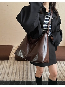 Détail du grand sac cabas marron foncé en cuir verni plissé porté à l'épaule