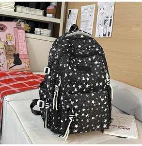 Detalle de mochila negra con estampado de estrellas blancas y siluetas de ositos