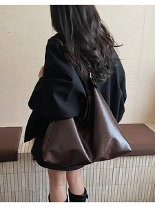 Détail du grand sac cabas marron foncé montrant le cuir brillant et la bandoulière