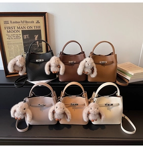 Sacs seaux en cuir grainé en six couleurs avec fermoir rotatif et breloque lapin en peluche