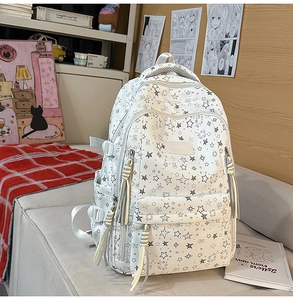 Detalle de la mochila con estampado de estrellas, diseño multibolsillo y borla decorativa