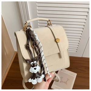 Detail of a creamy white PU leather backpack with a cute schnauzer charm and woven rope décor