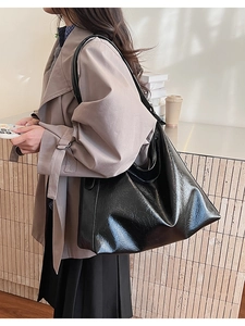 Détail d'un grand sac cabas noir en cuir huilé avec finition brillante et texture souple