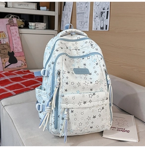 Detalle de la mochila azul claro con patrones de estrellas y osos y tiradores de cremallera