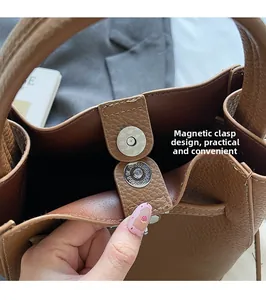 Détail du sac à main en cuir marron grainé avec fermeture à bouton pression aimanté