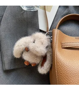Détail d'un charme lapin en peluche kaki avec pieds en cuir sur un sac seau chic