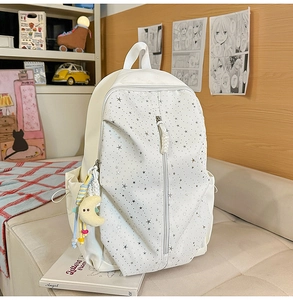 Detail of off-white star-print backpack featuring a cute moon plush charm and side pockets