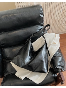 Détail d'un grand sac hobo en cuir noir brillant pour un look de bureau élégant