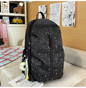 Detailed close-up of multi-layer star print backpack with moon plush keychain accessory