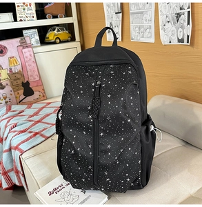 Detail of black backpack with white star pattern and side adjustable mesh pocket