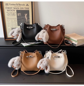 Group of litchi texture bucket bags in four colors with plush rabbit charms