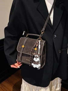 Retro dark brown crossbody bag with top handle and dog charm in polished leather finish