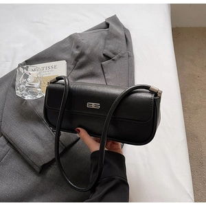 Close-up of black textured leather underarm bag with silver BB metal buckle and strap