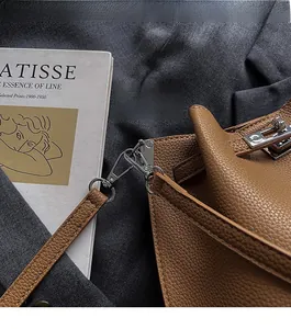 Detail of silver hardware buckle and pebble grain leather on brown bucket bag