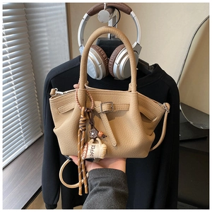 Close-up of beige lychee grain bucket bag featuring a coffee cup and tassel charm