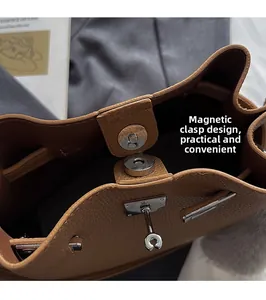 Detail of brown litchi leather handbag showing magnetic closure and silver twist lock