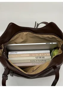 Internal view of a brown tote bag showing large capacity for laptops and books