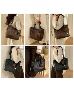 Detail view of large tote bag in black and brown styles with decorative charm