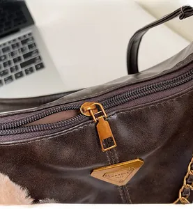 Detailed close-up of the smooth metal zipper and vintage leather texture of this brown tote bag